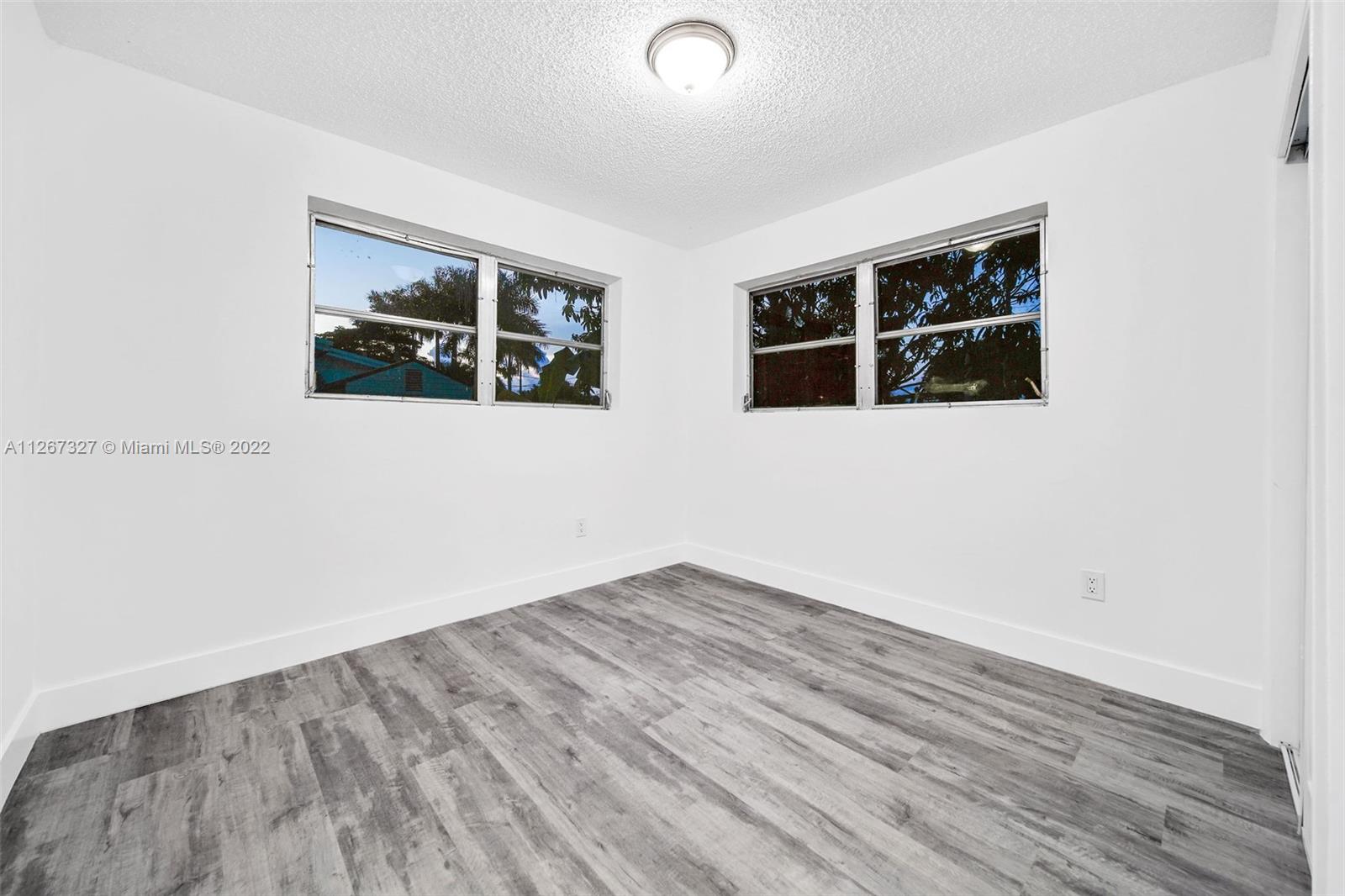 18951 Southwest 311th Street Homestead, FL 33030 - Photo 12 of 20 a view of an empty room with wooden floor and windows