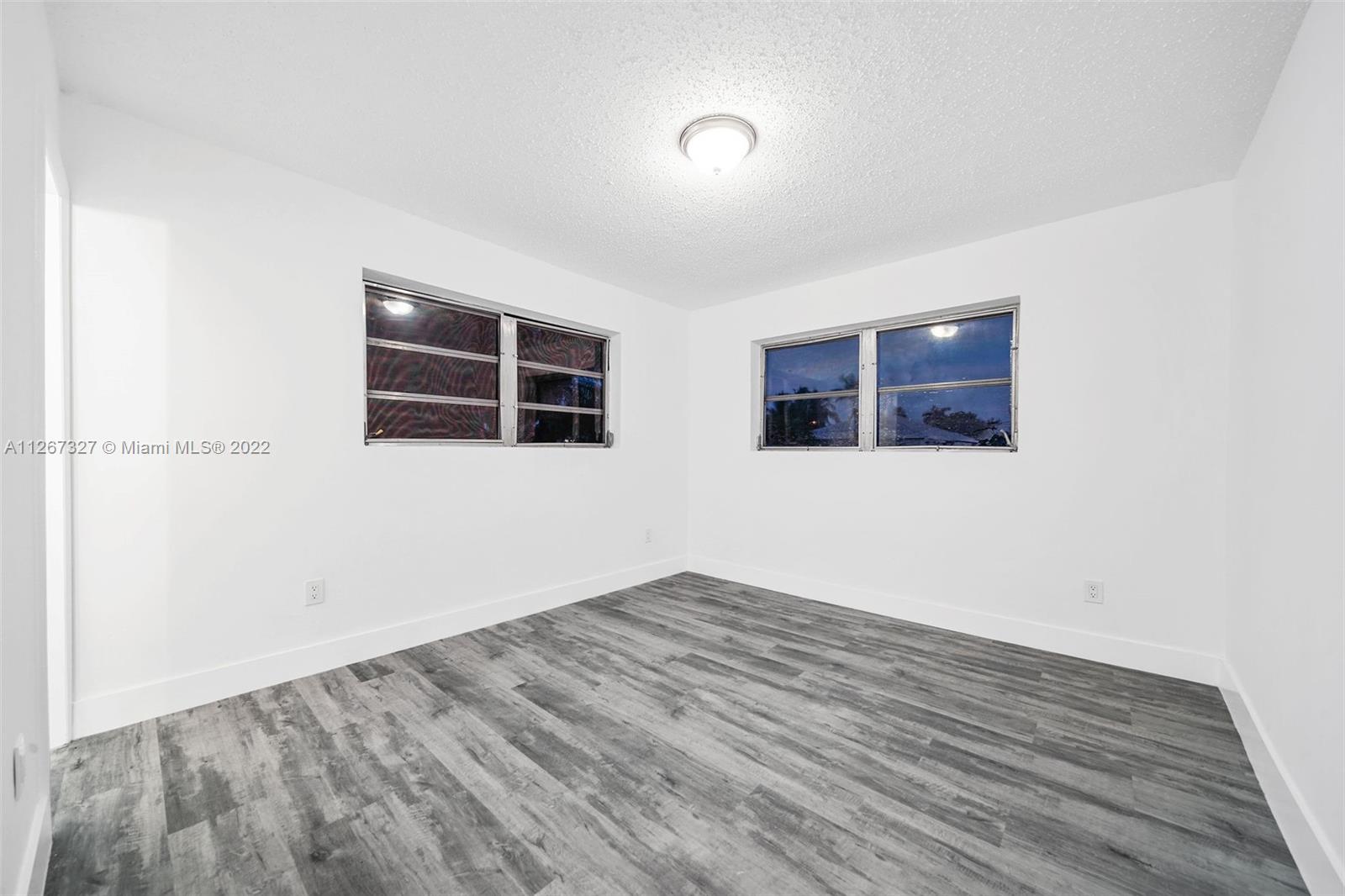 18951 Southwest 311th Street Homestead, FL 33030 - Photo 14 of 20 an empty room with wooden floor and windows