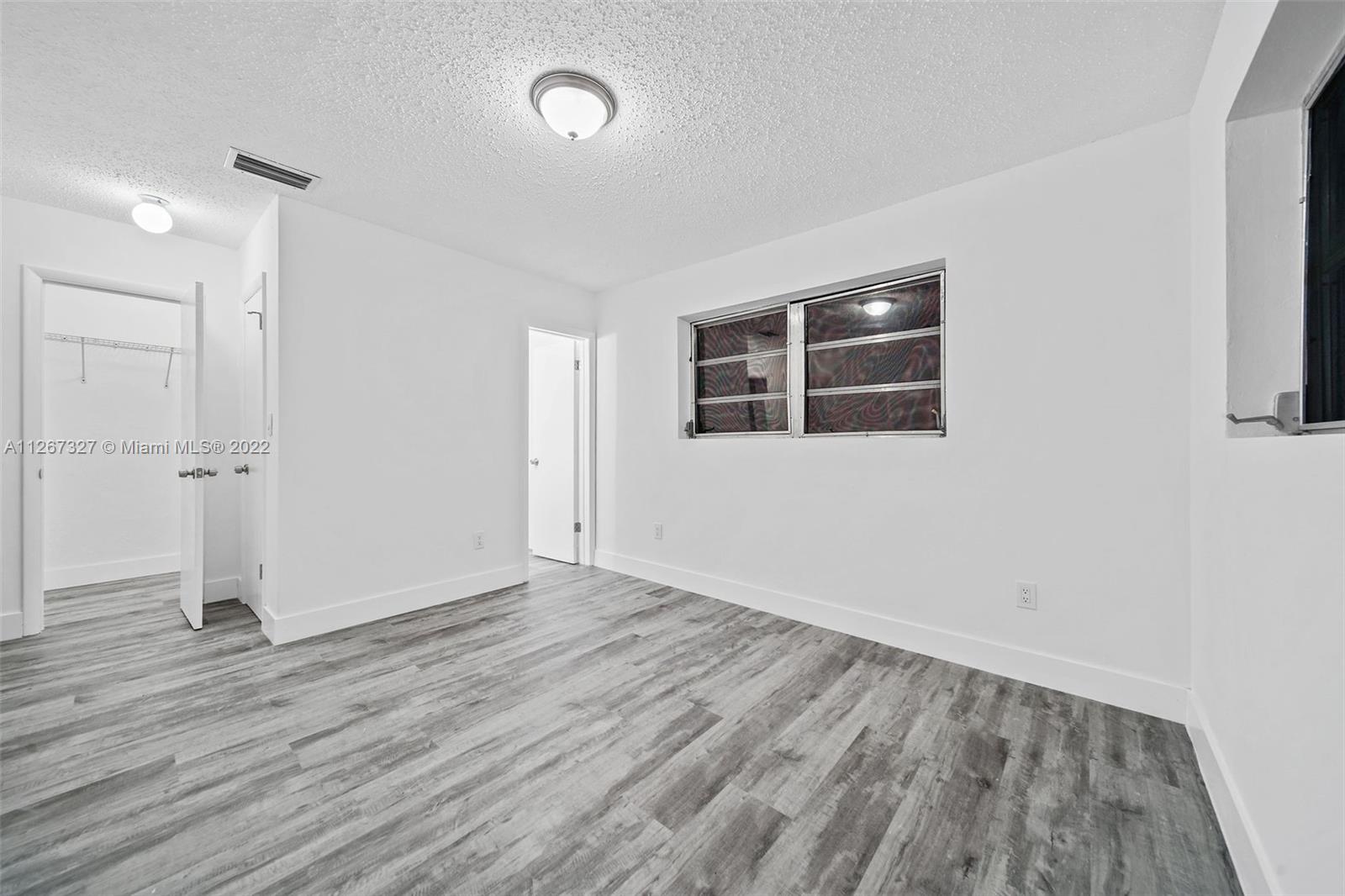 18951 Southwest 311th Street Homestead, FL 33030 - Photo 15 of 20 an empty room with wooden floor and windows