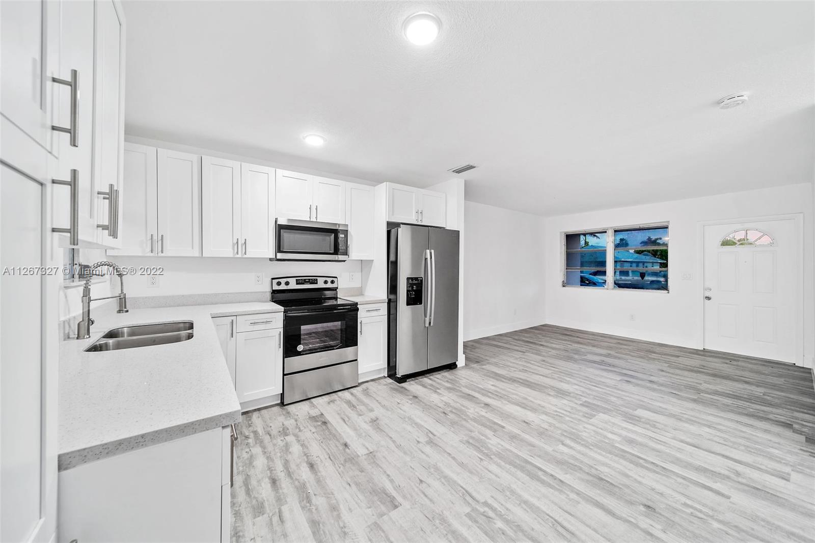 18951 Southwest 311th Street Homestead, FL 33030 - Photo 2 of 20 a kitchen with granite countertop a refrigerator and a stove top oven