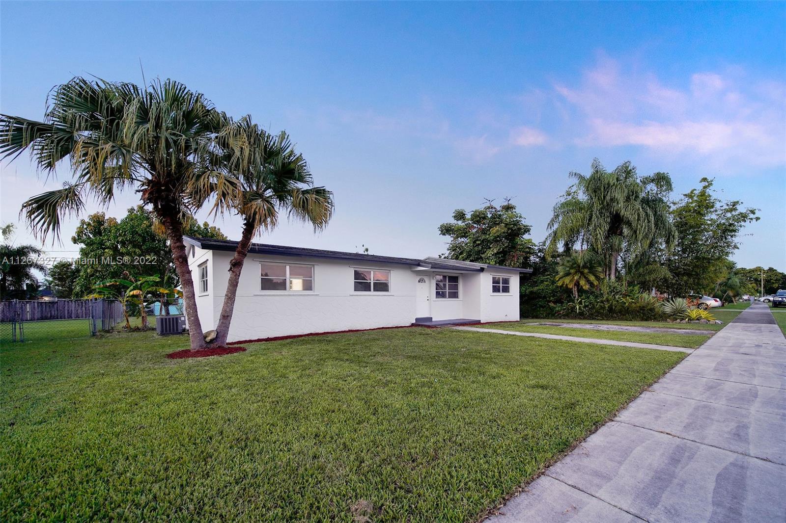 18951 Southwest 311th Street Homestead, FL 33030 - Photo 3 of 20 a front view of a house with a yard and garage