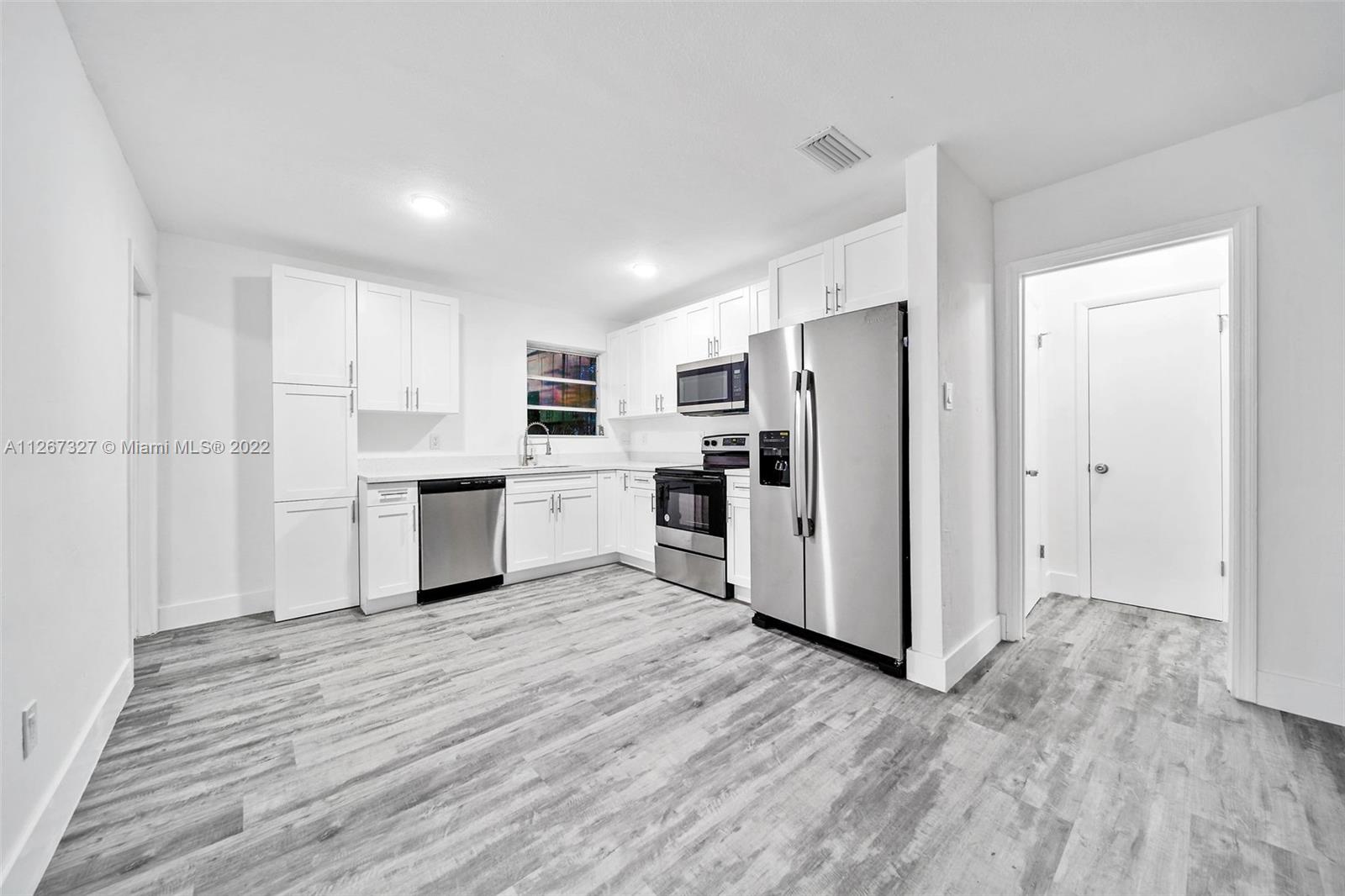 18951 Southwest 311th Street Homestead, FL 33030 - Photo 6 of 20 a kitchen with white cabinets and white appliances