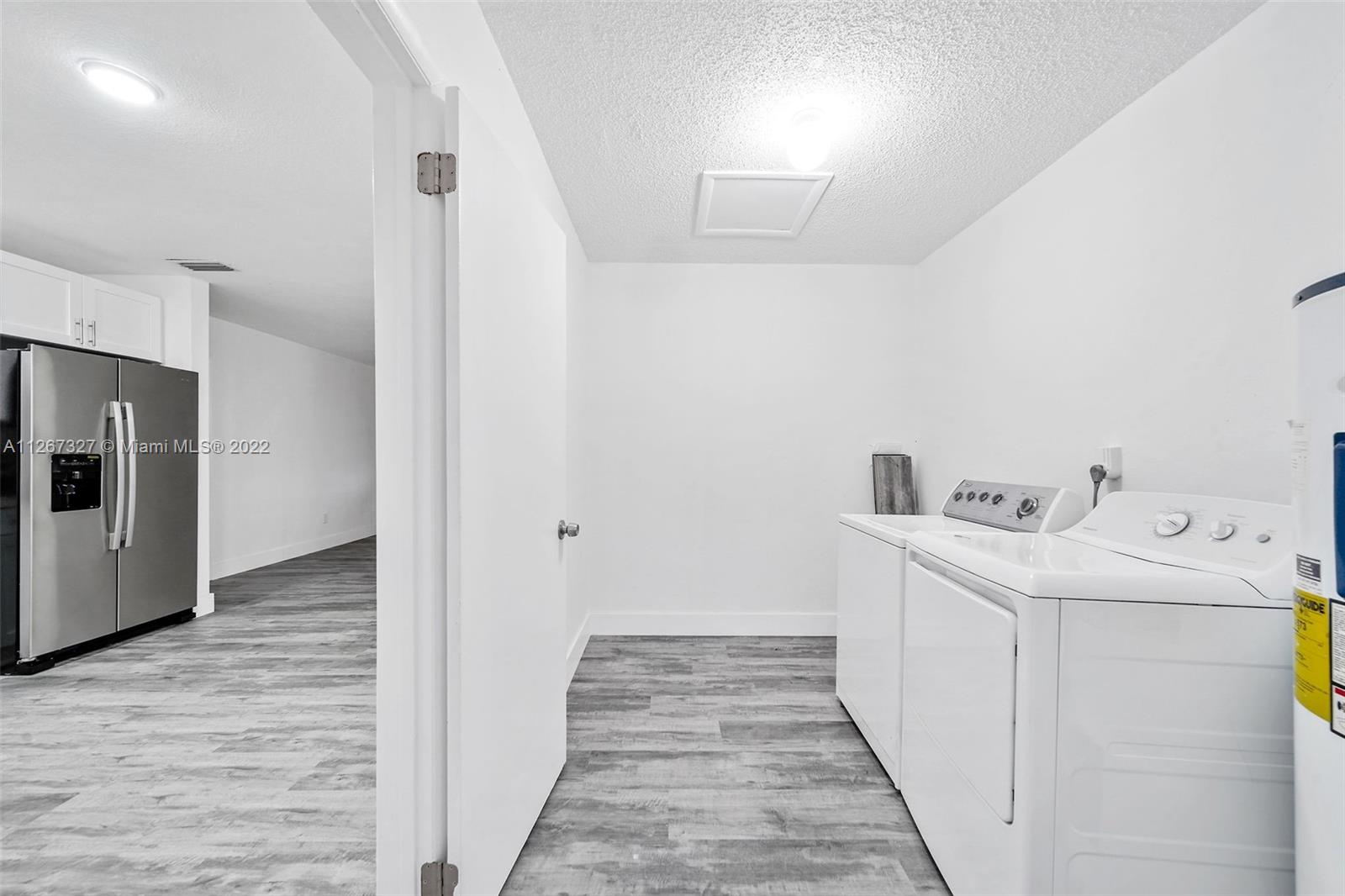 18951 Southwest 311th Street Homestead, FL 33030 - Photo 7 of 20 a utility room with wooden floor washer and dryer