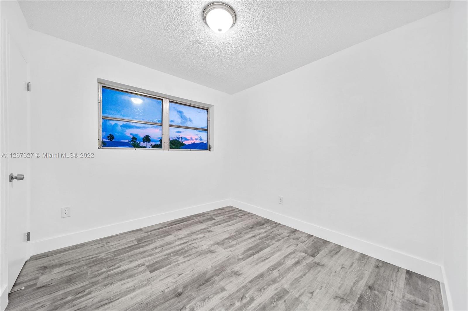 18951 Southwest 311th Street Homestead, FL 33030 - Photo 10 of 20 an empty room with wooden floor and window