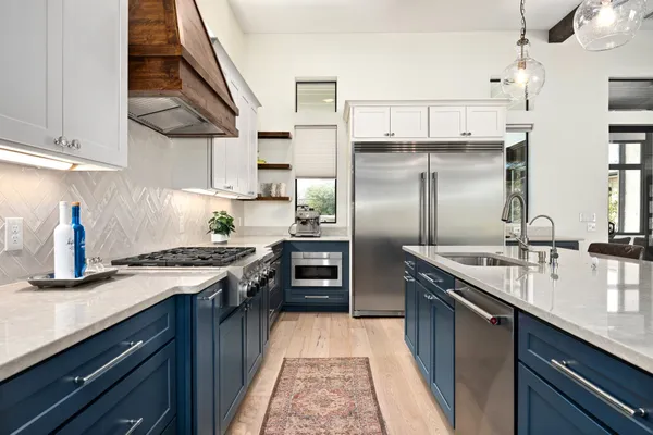 a kitchen with stainless steel appliances granite countertop a sink a stove and a refrigerator