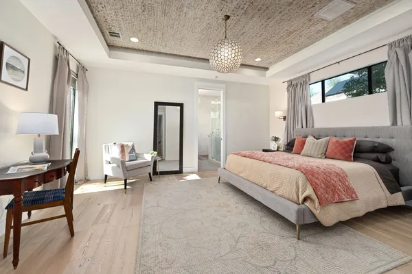 a spacious bedroom with a bed a table and large windows