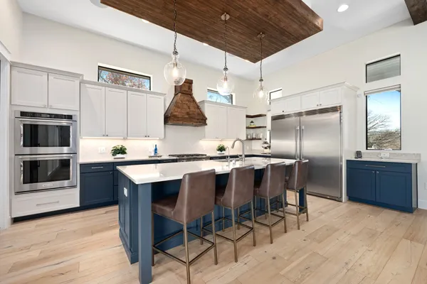 a kitchen with granite countertop a center island stainless steel appliances and cabinets