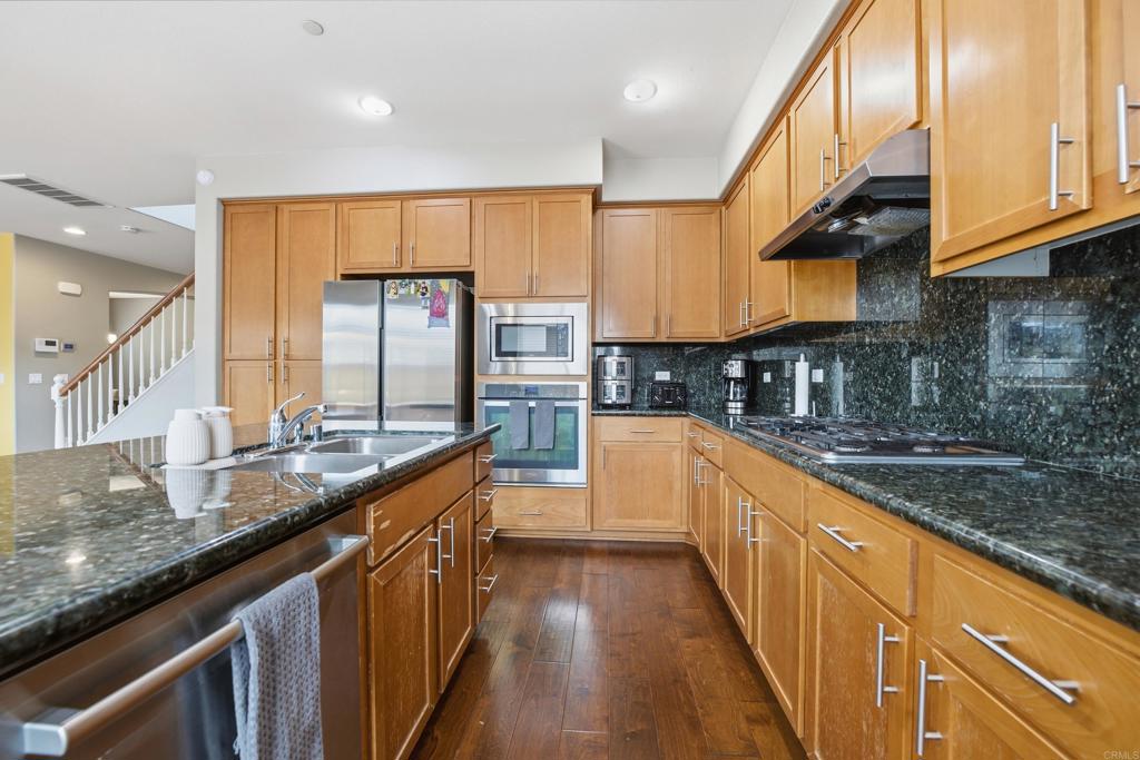 1746 Webber Way Chula Vista, CA 91913 - Photo 7 of 24 a kitchen with stainless steel appliances granite countertop a sink a stove top oven a counter space and cabinets
