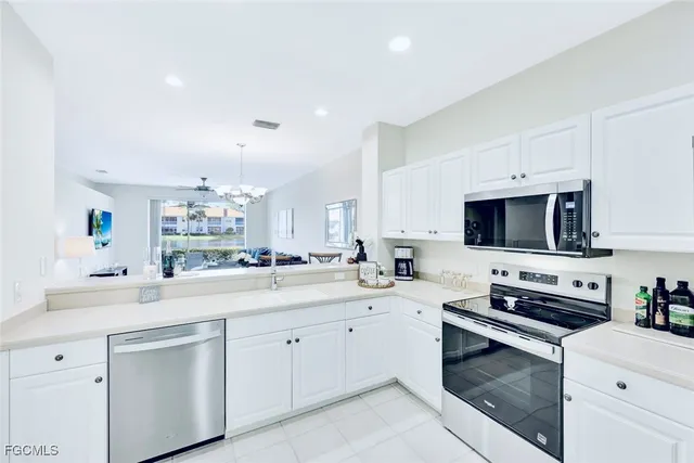 a kitchen with stainless steel appliances white cabinets sink and stove