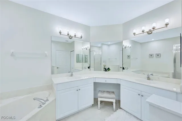 a spacious bathroom with a double vanity sink a mirror a bathtub and a shower