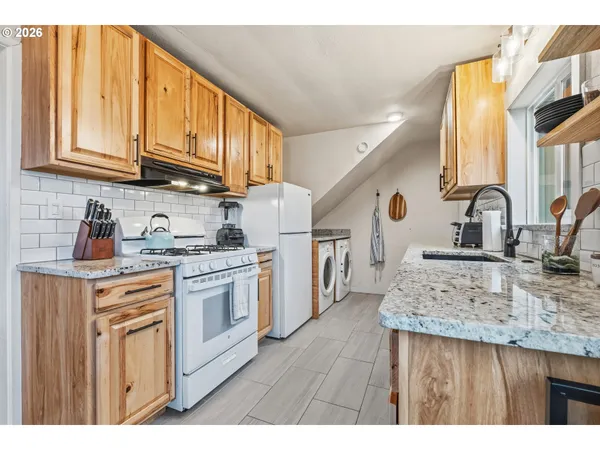 a kitchen with stainless steel appliances granite countertop a sink dishwasher stove and cabinets with wooden floor