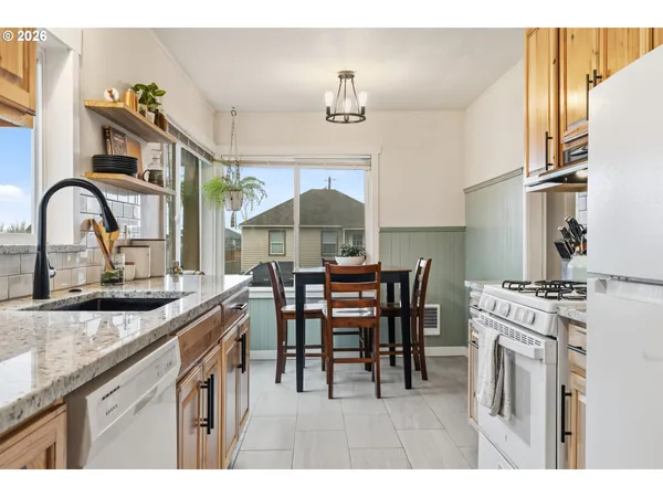 a kitchen with kitchen island a dining table chairs cabinets and stainless steel appliances
