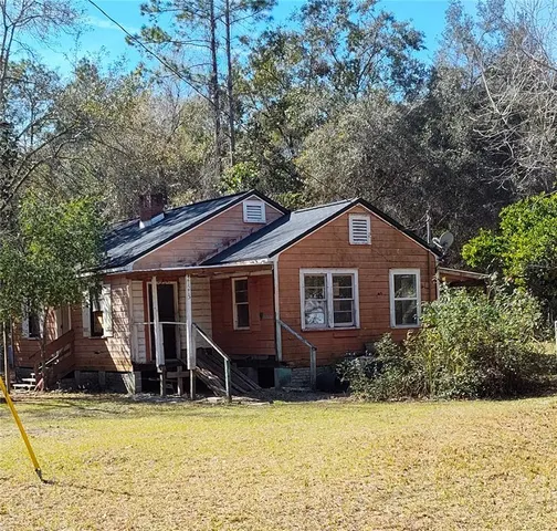 a view of a house with pool and chairs