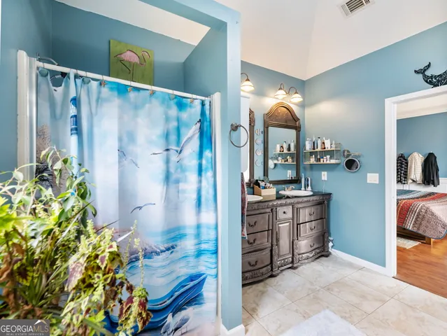 a bathroom with a sink a toilet a mirror and shower curtain