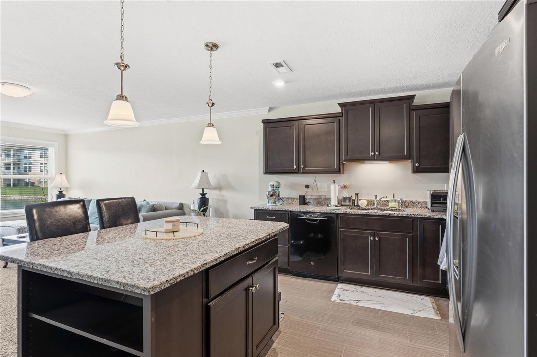141 Old Pond Road Springboro, OH 45066 - Photo 8 of 20 This modern kitchen features a spacious island and gleaming granite counters, perfect for culinary endeavors.