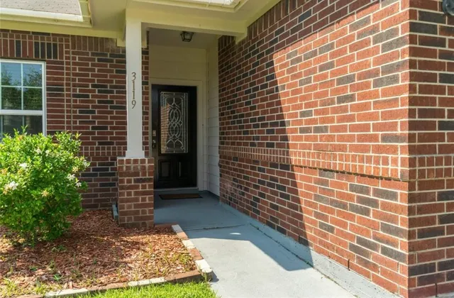 a view of a brick house with a yard