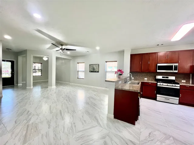 a large kitchen with a refrigerator and a sink