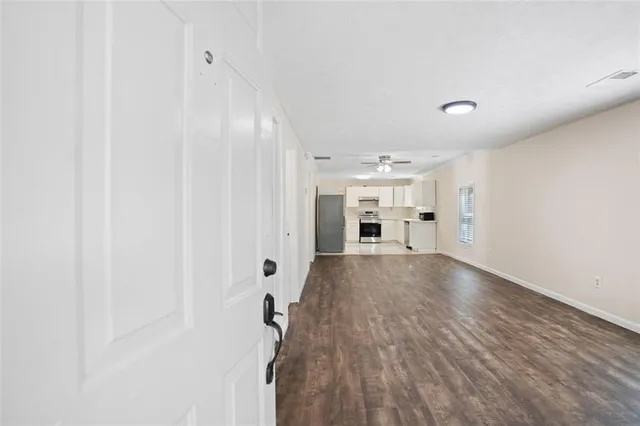 a view of empty room with wooden floor