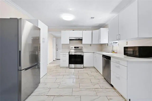 a kitchen with a refrigerator sink and cabinets
