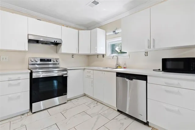 a kitchen with cabinets stainless steel appliances and sink