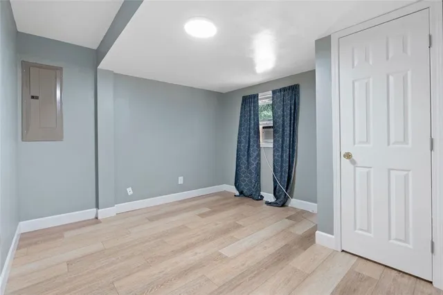 a view of an empty room with wooden floor