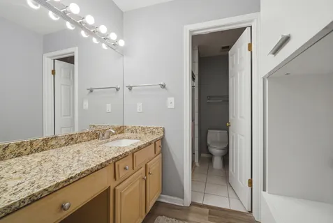 a bathroom with a granite countertop sink and a mirror