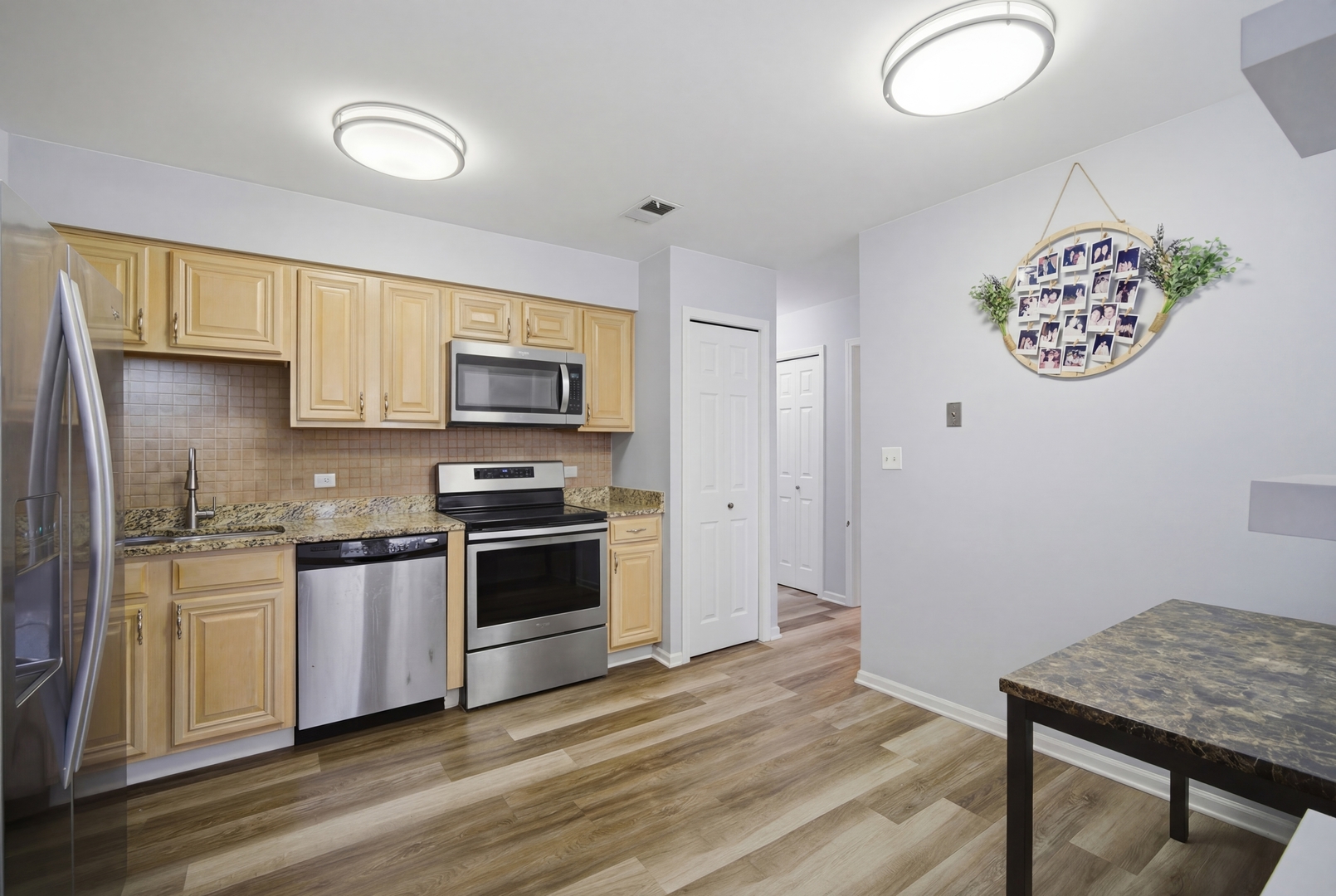 2113 Ammer Ridge Court, Unit 301 Glenview, IL 60025 - Photo 6 of 21 a kitchen with granite countertop a stove top oven a sink and a microwave