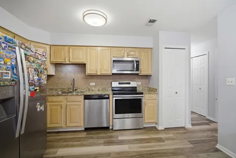a kitchen with stainless steel appliances granite countertop a stove a sink and a refrigerator