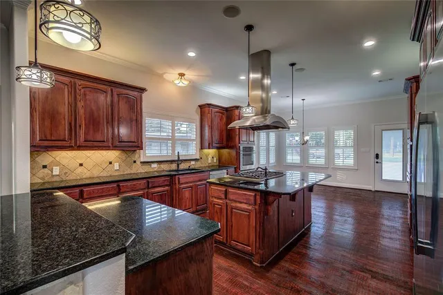 a kitchen with stainless steel appliances granite countertop a stove a sink and a microwave