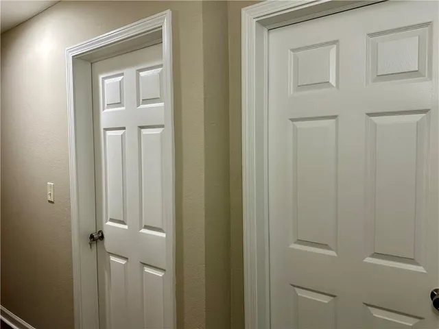 a view of an empty room with window and a ceiling fan