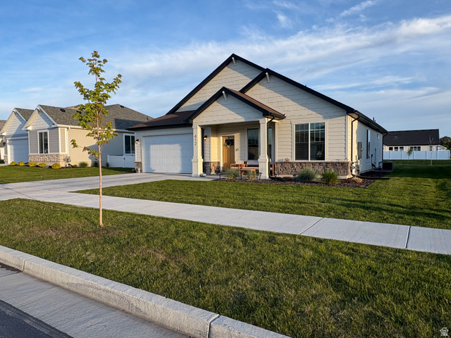 412 West 3025th Street South Logan, UT 84321 - Photo 4 of 34 Craftsman inspired home with stone siding, concrete driveway, a front yard, a garage, and a porch