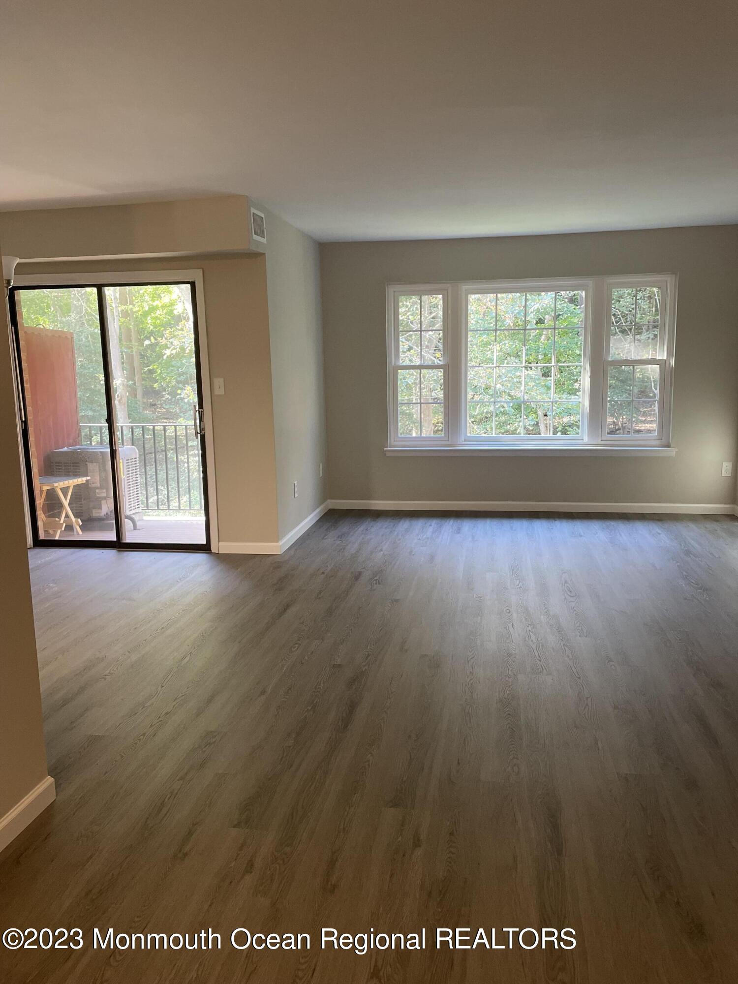 200 Portland Road, Unit E15 Highlands, NJ 07732 - Photo 3 of 21 an empty room with wooden floor and windows