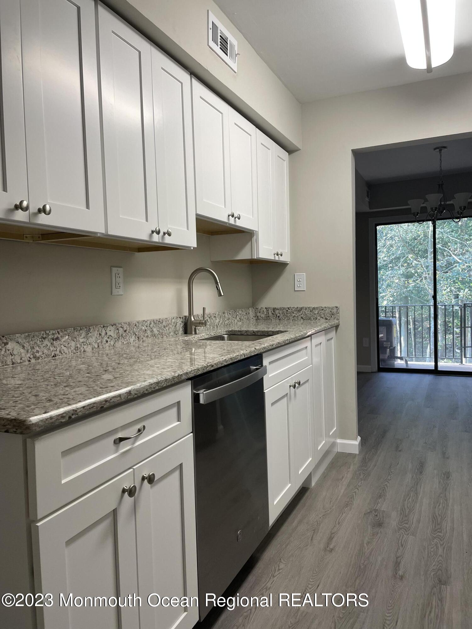200 Portland Road, Unit E15 Highlands, NJ 07732 - Photo 4 of 21 a kitchen with granite countertop stainless steel appliances a stove a sink and a microwave