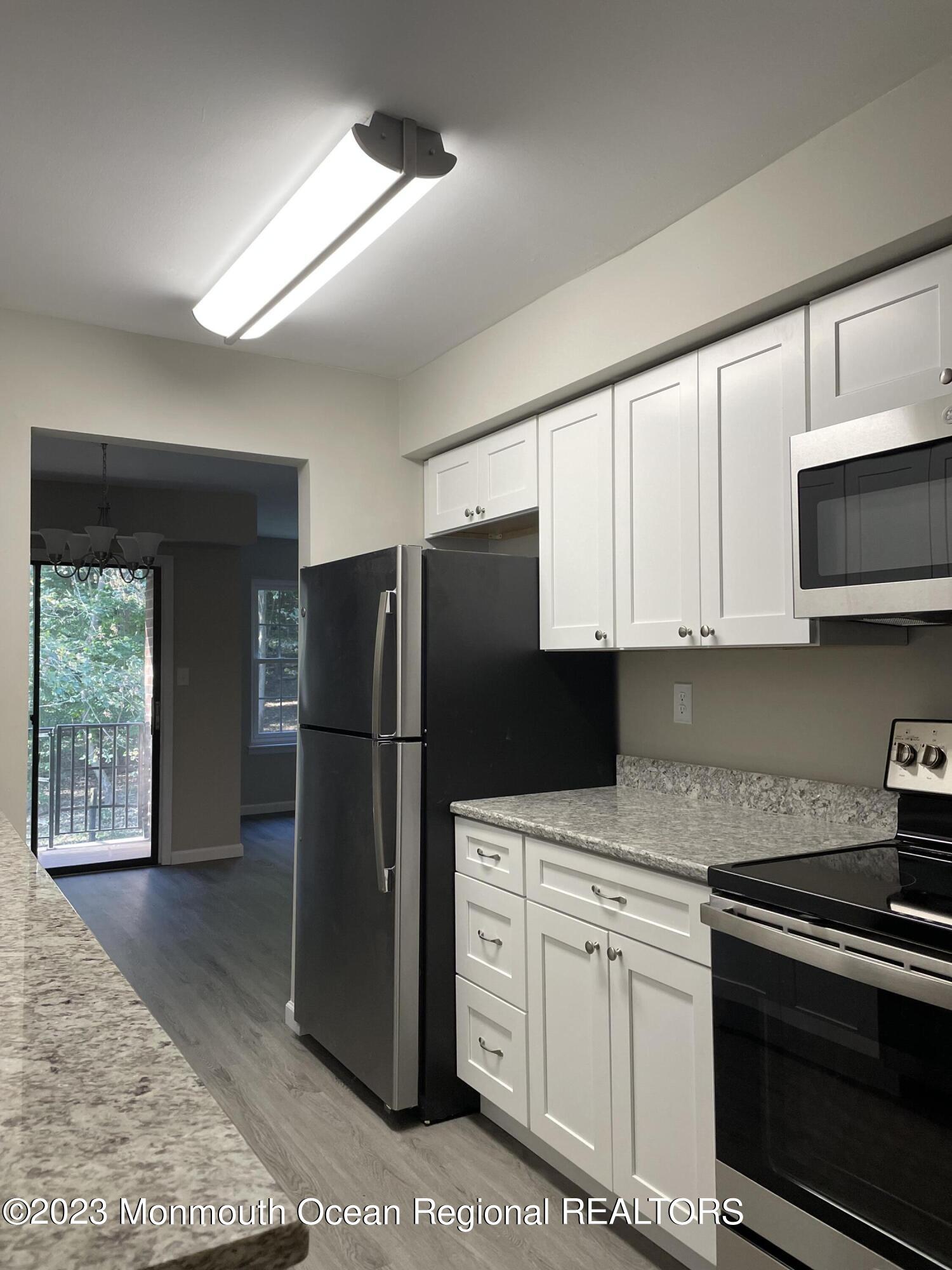 200 Portland Road, Unit E15 Highlands, NJ 07732 - Photo 5 of 21 a kitchen with stainless steel appliances white cabinets and a refrigerator