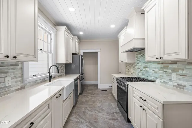a kitchen with granite countertop a stove sink and cabinets