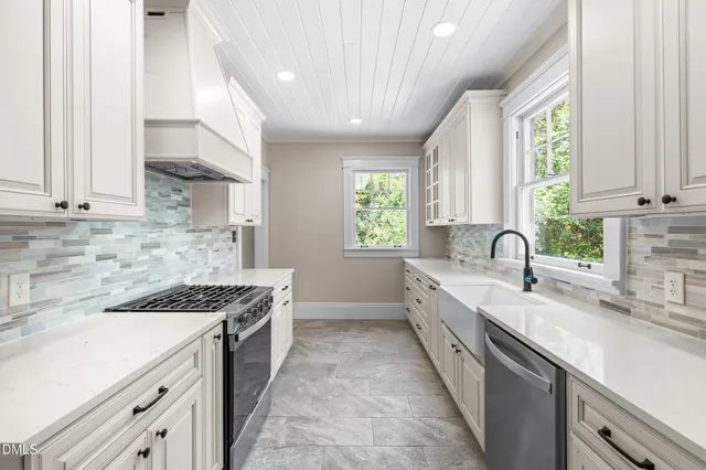 a kitchen with granite countertop white cabinets and a window