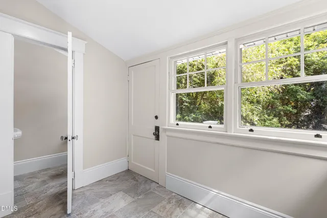 a view of a backyard with potted plants and large trees
