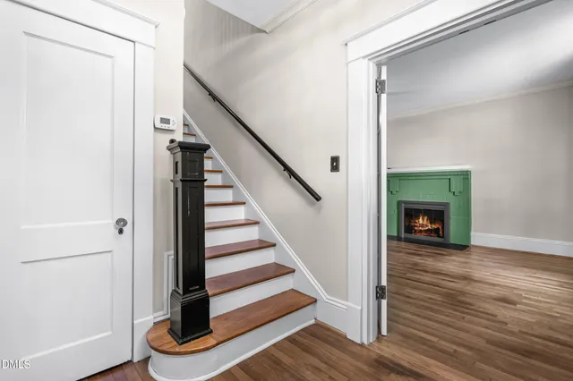 a view of a hallway with wooden floor and a fireplace