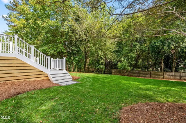 an aerial view of a house with a yard and table and chairs under an umbrella