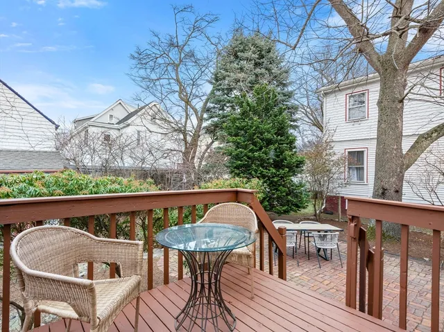 a roof deck with table and chairs and wooden floor