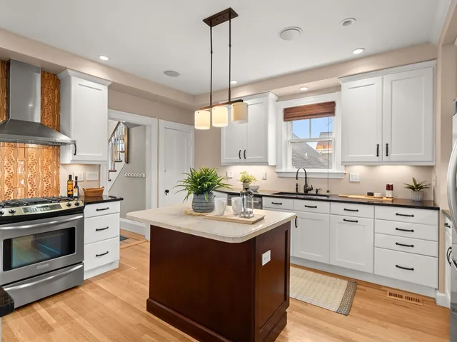 a kitchen with stainless steel appliances granite countertop a sink a stove and a refrigerator