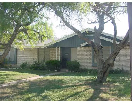 a view of a yard in front of a house with large tree