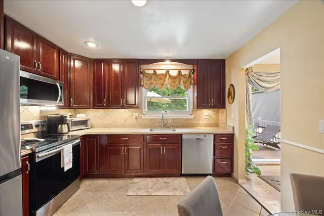 a kitchen with stainless steel appliances granite countertop wooden cabinets a sink and a stove