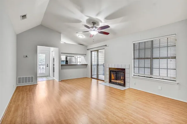 a view of an empty room with a fireplace and a window
