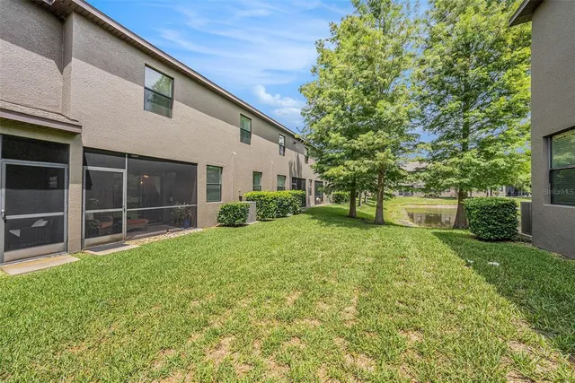 a view of backyard with large trees and a small yard