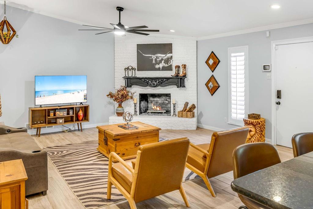 3330 Timberview Road Dallas, TX 75229 - Photo 11 of 39 Living room with wood-type flooring, a brick fireplace, ceiling fan, and ornamental molding
