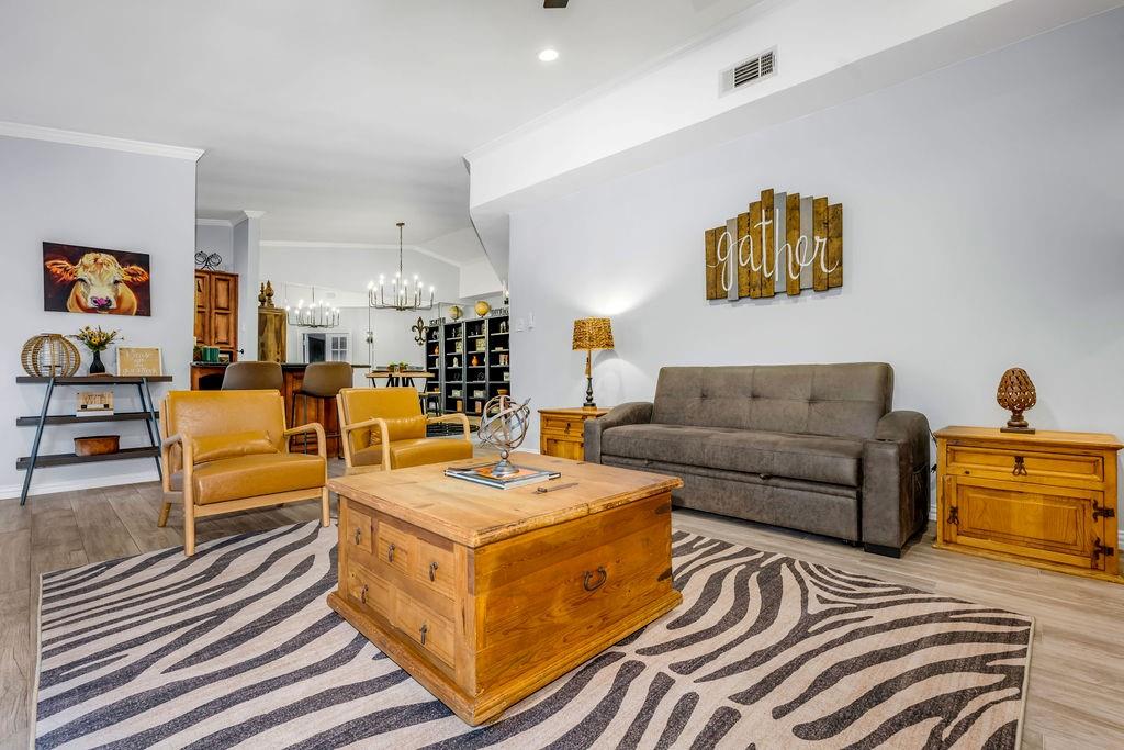 3330 Timberview Road Dallas, TX 75229 - Photo 13 of 39 Living room with an inviting chandelier, light hardwood / wood-style floors, and ornamental molding