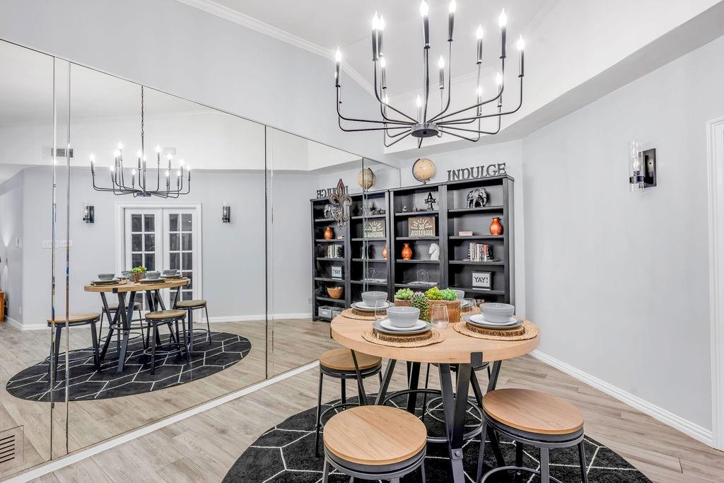 3330 Timberview Road Dallas, TX 75229 - Photo 21 of 39 Dining area with a chandelier, a towering ceiling, and wood-type flooring