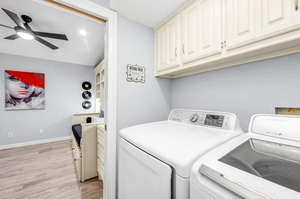 3330 Timberview Road Dallas, TX 75229 - Photo 28 of 39 Laundry area with ceiling fan, light hardwood / wood-style flooring, cabinets, and independent washer and dryer