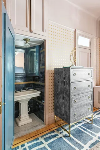 a bedroom with a bed and a large mirror on the dresser